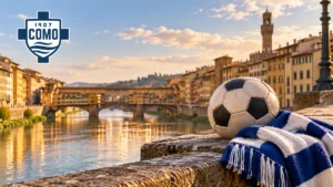 Pallone e sciarpa biancoblù su un parapetto lungo l’Arno, con Ponte Vecchio sullo sfondo e logo Como 1907 in alto a sinistra.